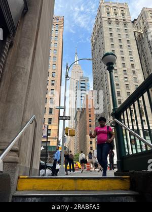 Verlassen Sie die U-Bahn-Station 33. Street #6 und fahren Sie in die vertikale Stadt, wobei das Empire State Building in Manhattan geradeaus Richtung Westen verläuft. Stockfoto