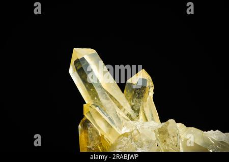 Natürlicher Citrinkristall, isoliert auf schwarzem Hintergrund. Makrodetails Nahaufnahme grober roher, unpolierter Schmuckstein. Stockfoto