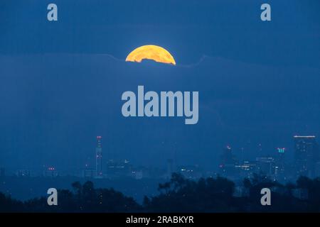 Birmingham, Großbritannien. 2. Juli 2023. Der Vollmond erhebt sich über einer Wolkenbank über Birmingham, Großbritannien. Der Vollmond im Juli – auch als „Buck moon“ bezeichnet – wird der erste von vier aufeinanderfolgenden supermonden sein – Vollmonde, die etwas größer und heller als der durchschnittliche Vollmond zu sein scheinen, da ihr Orbit näher an der Erde liegt, wenn sie ihre volle Phase erreichen. Kredit: Peter Lopeman/Alamy Live News Stockfoto