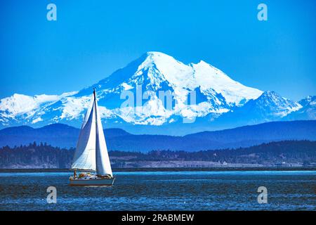 Teleeinstellung Nahaufnahme eines Segelboots vor einem schneebedeckten Mt. Baker, Cascade Range, Washington, USA Stockfoto