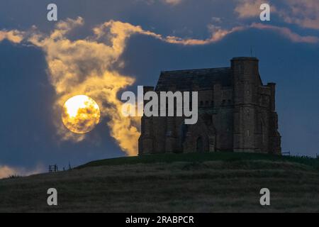 Abbotsbury, Dorset, Großbritannien. 2. Juli 2023 Wetter in Großbritannien. Der fast volle Buck-Supermond wird von Wolken verdeckt, wenn er sich hinter der Katharinenkapelle in Abbotsbury in Dorset erhebt. Bildnachweis: Graham Hunt/Alamy Live News Stockfoto