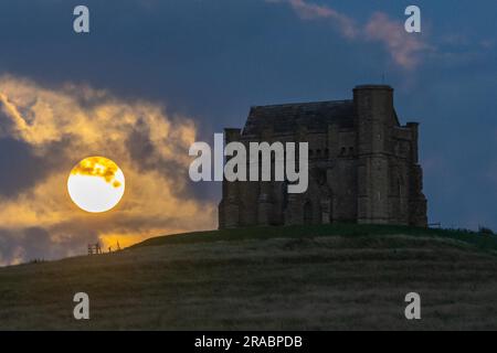 Abbotsbury, Dorset, Großbritannien. 2. Juli 2023 Wetter in Großbritannien. Der fast volle Buck-Supermond wird von Wolken verdeckt, wenn er sich hinter der Katharinenkapelle in Abbotsbury in Dorset erhebt. Bildnachweis: Graham Hunt/Alamy Live News Stockfoto