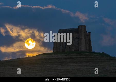 Abbotsbury, Dorset, Großbritannien. 2. Juli 2023 Wetter in Großbritannien. Der fast volle Buck-Supermond wird von Wolken verdeckt, wenn er sich hinter der Katharinenkapelle in Abbotsbury in Dorset erhebt. Bildnachweis: Graham Hunt/Alamy Live News Stockfoto