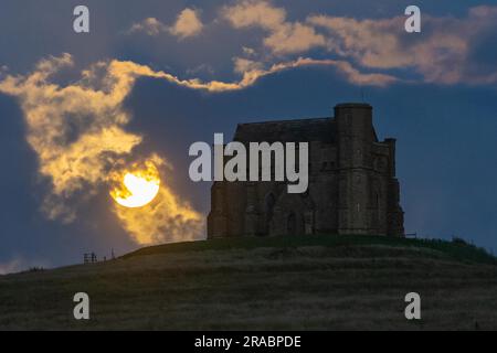 Abbotsbury, Dorset, Großbritannien. 2. Juli 2023 Wetter in Großbritannien. Der fast volle Buck-Supermond wird von Wolken verdeckt, wenn er sich hinter der Katharinenkapelle in Abbotsbury in Dorset erhebt. Bildnachweis: Graham Hunt/Alamy Live News Stockfoto