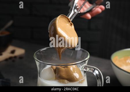 Eine Frau, die Dalgona-Kaffee auf dunklem Hintergrund macht, Nahaufnahme Stockfoto