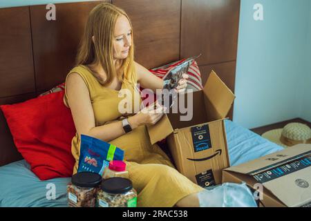 12.21.22, Mexiko, Playa del Carmen: Eine schwangere Frau erhielt ein Paket von Amazon. Die Frau zieht die Nuss heraus, die sie bei Amazon bestellt hat. Online Stockfoto