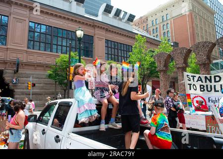 Kinder mit Pride Flags und Blasen sitzen im Bett eines Pickup-Trucks vor dem Philadelphia Downtown Marriott während eines Protests der Philly Children's Movement gegen Moms for Liberty im Center City Philadelphia. MUM's for Liberty, eine Gruppe aus dem Jahr 2021 zur Bekämpfung von COVID-19-Mandaten, hielt ihren jährlichen Gipfel in Philadelphia, Pennsylvania, ab und trafen sich mit Demonstranten, die gegen das Ereignis und die Aktionen von MUM's for Liberty protestierten. Die Gruppe, die vom Southern Poverty Law Center als Hass-Gruppe bezeichnet wird, hat in der Anti-LGBT-Rhetorik und dem Druck, bestimmte zu verbieten, eine Stimme abgegeben Stockfoto