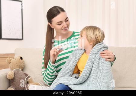 Mutter hilft ihrem kranken Sohn bei der Inhalation von Verneblern zu Hause Stockfoto