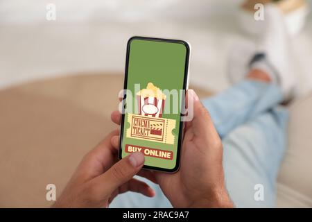 Ein Mann kauft Kinokarten online über ein Handy zu Hause, Nahaufnahme Stockfoto