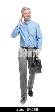 Ein erwachsener Geschäftsmann, der mit seinem Smartphone vor weißem Hintergrund spricht Stockfoto