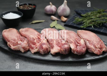 Rohe Rindfleisch-Zungenstücke auf grauem Tisch Stockfoto