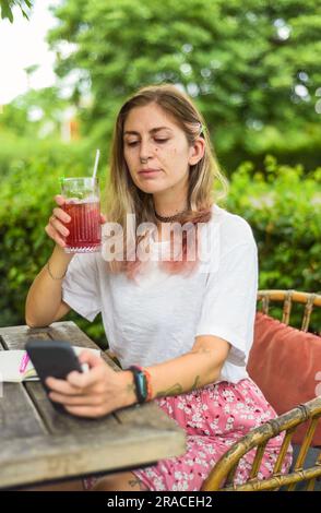 Süße Frau, die im Sommergarten Tee trinkt Stockfoto