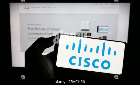 Person, die ein Smartphone mit dem Logo des US-amerikanischen Kommunikationsunternehmens Cisco Systems Inc. Auf dem Bildschirm vor der Website hält. Konzentrieren Sie sich auf das Display des Telefons. Stockfoto