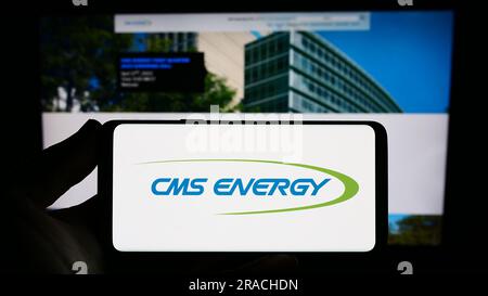 Person, die ein Smartphone mit dem Logo des US-Versorgungsunternehmens CMS Energy Corporation auf dem Bildschirm vor der Website hält. Konzentrieren Sie sich auf das Display des Telefons. Stockfoto