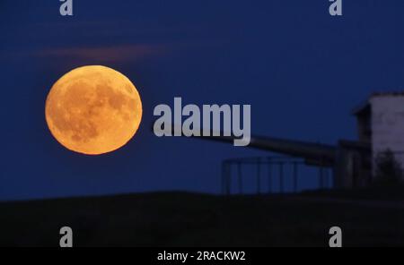 Der Full Buck-Supermond erhebt sich über den Kanon in Blyth Battery in Northumberland. Der Juli-Supermond erreicht seinen nächstgelegenen Punkt zur Erde mit 224.895 Meilen (361.934km km) - etwa 13.959 Meilen (22.466km km) näher als üblich. Es erscheint 5,8 Prozent größer und 12,8 Prozent heller als ein normaler Vollmond. Foto: Sonntag, 2. Juli 2023. Stockfoto