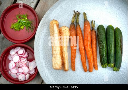 Geröstete Pastinaken, Karotten und Zucchini auf einem hellgrauen Teller Stockfoto