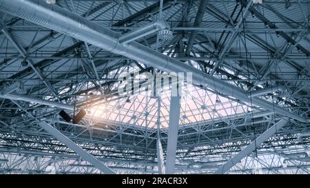 Glasdecke, durch die die Sonne eindringt, Dachbalken aus Metall im Inneren, Deckenfragment aus Metalldach des Industriegebäudes Stockfoto