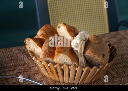 Nahaufnahme eines Holztellers mit einer anderen Art köstlichem appetitlichen Brot auf dem Tisch Stockfoto