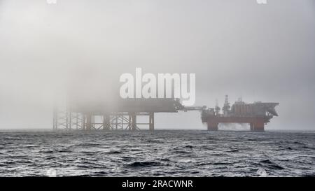 Von Nebel im Ozean bedeckte Offshore-Anlage zur Erdölförderung. Bohrfahrzeug aufbocken, halbtauchfähige Plattform mit Nebel im Meer bedeckt. Stockfoto