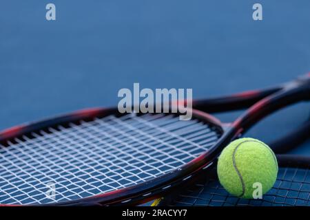 Nahaufnahme von Tennisball und Tennisschlägern, die auf dem Tennisplatz liegen Stockfoto