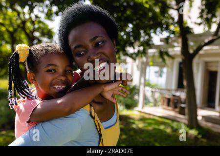 Nahaufnahme einer afroamerikanischen, fröhlichen Mutter, die im Garten steht Stockfoto