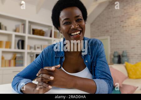 Glückliche afroamerikanische Frau, die zu Hause Videoanrufe macht Stockfoto