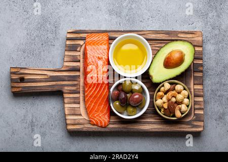 Nahrungsquellen für gesundes ungesättigtes Fett: Frisches Lachsfilet, Avocado, Oliven und Nüsse Stockfoto