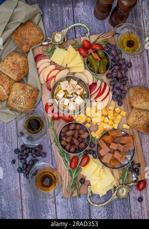 Käseplatte mit Obst, Oliven, Trauben und Brot Stockfoto