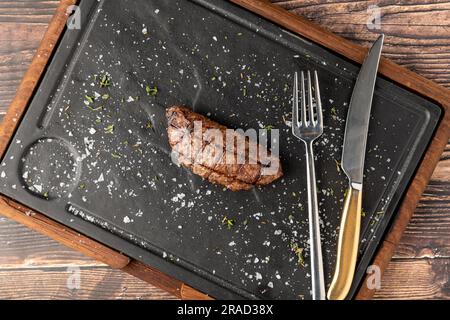 Fleischklößchen mit gegrilltem Cheddar auf einem Steinschneidebrett im Steakhouse-Restaurant Stockfoto