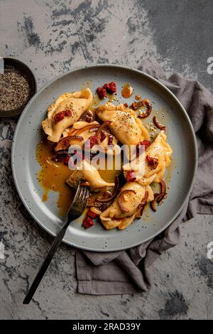 Käse und Kartoffel-Ravioli mit Zwiebeln, Butter und Wurst Stockfoto