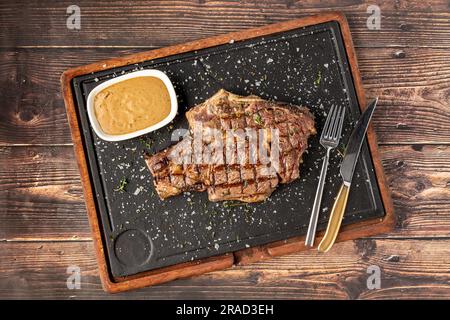 Gegrilltes Tomahawk-Steak auf einem Steinschneidebrett im Steakhouse-Restaurant Stockfoto