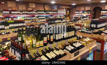 Flaschen mit leeren Etiketten auf der Theke eines Spirituosengeschäfts. Wein-Hintergrund. Stockfoto