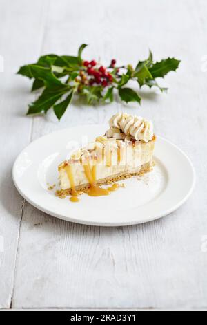 Weihnachtskäsekuchen mit gesalzenen Karamellmandeln und Schlagsahne Stockfoto