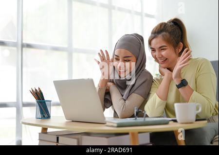 Eine junge Gruppe von Studenten, die eine Videokonferenz mit einem Laptop führen. Stockfoto