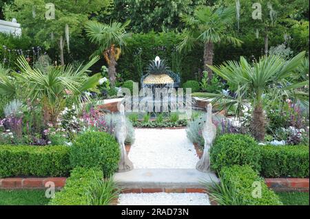 Eröffnungstag beim 2023 Royal Horticultural Society Hampton Court Palace Garden Festival - einer der ausgestellten Show Gardens: Der Explore Charleston Garden mit seiner detailreichen Gartenanlage, den ausgeprägten Geräuschen des Wassers, Ananassymbolen und umschlossenen Grünflächen soll Besuchern einen Blick auf die historischen Hofgärten von Charleston, South Carolina, geben, die ihren Geist, Charme, Eleganz und Atmosphäre einfangen. Das Hampton Court Palace Garden Festival, das seit 1993 stattfindet, ist die renommierteste Blumen- und Gartenveranstaltung im Vereinigten Königreich und die weltweit größte jährliche Blumenpest Stockfoto