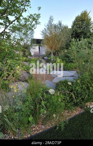 Eröffnungstag beim 2023 Royal Horticultural Society Hampton Court Palace Garden Festival - einer der ausgestellten Show Gardens: The Cancer Research UK Legacy Garden der Garten ist ein ruhiger Wald, der seinen Besuchern die Möglichkeit bietet, sich mit der Natur zu verbinden. So haben sie Zeit zum Nachdenken und zur Wertschätzung derer, die ein vererbtes Geschenk hinterlassen und die entscheidende Rolle, die dies bei der Bekämpfung von Krebs für künftige Generationen spielt. Das Hampton Court Palace Garden Festival, das seit 1993 stattfindet, ist die renommierteste Blumen- und Gartenveranstaltung im Vereinigten Königreich und die weltweit größte jährliche Blumenausstellung. Das dauert 18 Monate Stockfoto