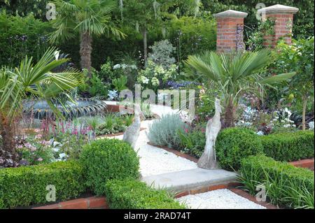 Eröffnungstag beim 2023 Royal Horticultural Society Hampton Court Palace Garden Festival - einer der ausgestellten Show Gardens: Der Explore Charleston Garden mit seiner detailreichen Gartenanlage, den ausgeprägten Geräuschen des Wassers, Ananassymbolen und umschlossenen Grünflächen soll Besuchern einen Blick auf die historischen Hofgärten von Charleston, South Carolina, geben, die ihren Geist, Charme, Eleganz und Atmosphäre einfangen. Das Hampton Court Palace Garden Festival, das seit 1993 stattfindet, ist die renommierteste Blumen- und Gartenveranstaltung im Vereinigten Königreich und die weltweit größte jährliche Blumenpest Stockfoto