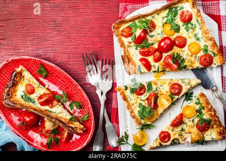 Köstlich einfache Tomatentorte mit Blätterteig, roten und gelben Kirschtomaten, Spinat und Ricotta-Käse. Die perfekte Vorspeise für den Sommer. Co Stockfoto