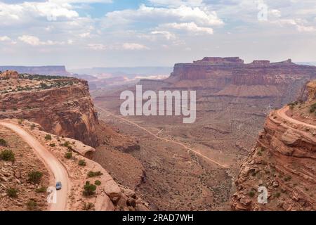 Blick auf ein Auto auf der White Rim Road vom Shafer Canyon tr Stockfoto