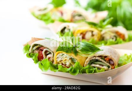 Auswahl an frischen Tortilla-Wraps mit Huhn, Käse und Gemüse. Gesundes Fast Food Stockfoto