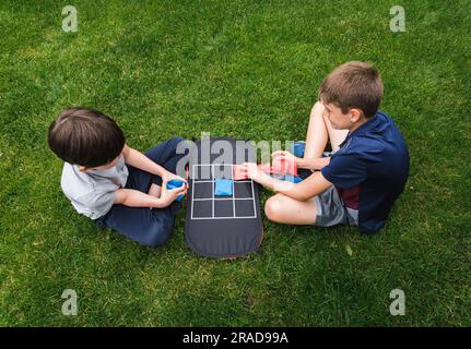 Aufnahmen von zwei Jungen, die Tic tac Toe spielen. Stockfoto
