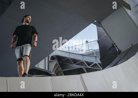 Porträt eines Freerunning Athleten, der auf der Metallkonstruktion steht. Ich Suche nach einem Ort für deine Werbung Stockfoto