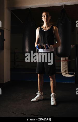 Junger Boxer steht mit Sprungseil und fängt mit dem Training im Fitnessstudio an. Stockfoto