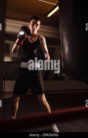 Junger Boxer, bereit, Boxen mit Boxsack zu üben. Stockfoto