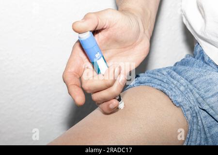 Ein Mann injiziert Insulin in sein Bein. Insulininjektions-Pen oder Insulinpatronen-Pen für Diabetiker. Medizinische Geräte für Diabetesvorsteher. Stockfoto