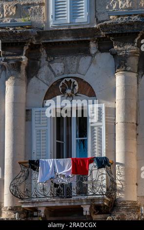 Die Wäsche hing über einem kunstvoll verzierten Geländer auf dem Balkon eines historischen Gebäudes in Split, kroatien. Wäsche hängt über den Geländern eines Balkons zum Trocknen Stockfoto