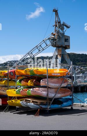 Farbenfrohe Kajaks stapeln sich an der Hafenmauer am Great Harbour Way im Hafengebiet Wellington, Hauptstadt Neuseelands Stockfoto