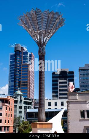 Eine riesige Palme spiegelt sich in der Skyline der Innenstadt am Great Harbour Way in Wellington, Hauptstadt Neuseelands, wider Stockfoto