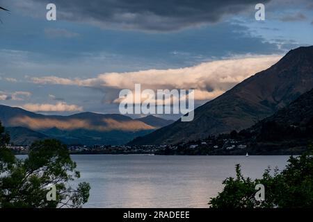 Wunderschöne abendliche Wolken und Wellen von Sonnenlicht über Frankton und Arrowtown nördlich von Queenstown auf Neuseeland South Island. Foto: Rob Watkins Stockfoto