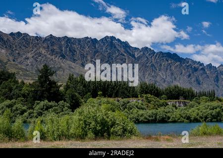 Die berühmten Remarkables Mountains liegen oberhalb des beliebten Radweges, der nördlich von Queenstown auf Neuseeland South Island verläuft. Foto: Rob Watkins Stockfoto